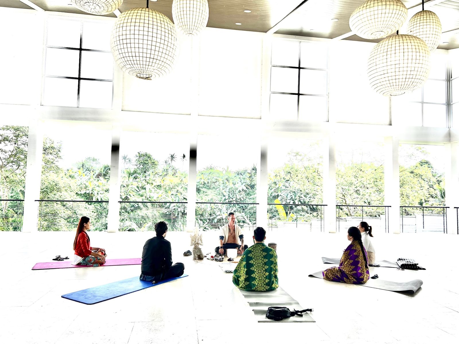 Dylan Ewing leading a small retreat session in a bright hall with lanterns